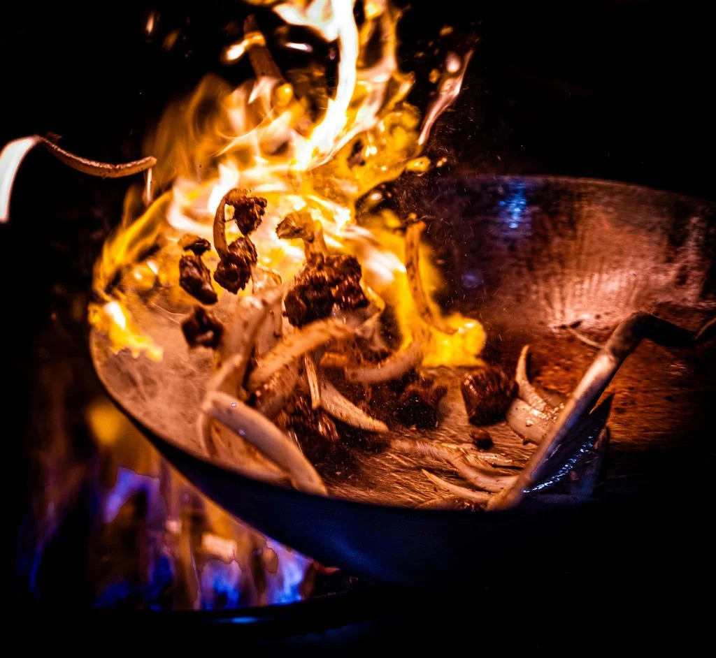 Wok flaming over high heat in Mia's kitchen